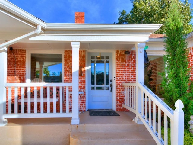 1821 Coventry Ln, Nichols Hills, OK 73120 - doorway to property featuring a porch, brick siding, and a chimney
