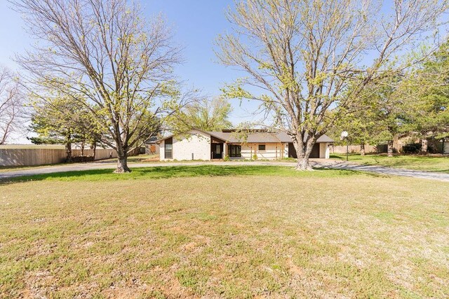 view of yard with driveway and fence