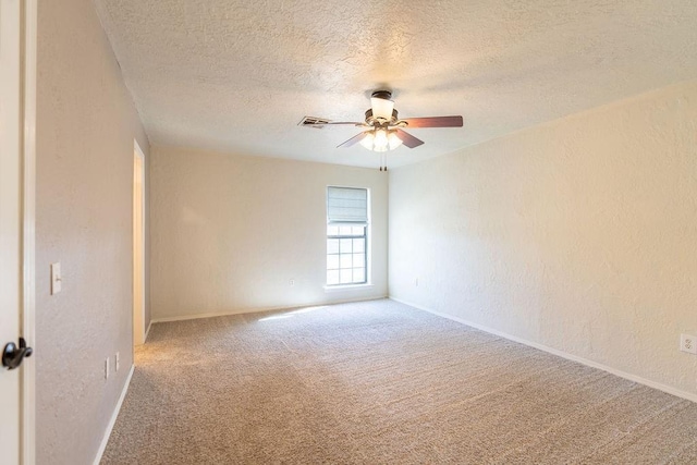 carpeted spare room featuring a textured wall, a textured ceiling, baseboards, and ceiling fan