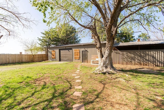 view of yard featuring a garage, an outdoor structure, and fence