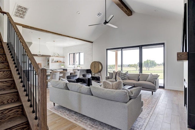 2223 Wintercreek Blvd, Blanchard, OK 73010 - living area with high vaulted ceiling, beam ceiling, light wood-type flooring, ceiling fan, and stairway