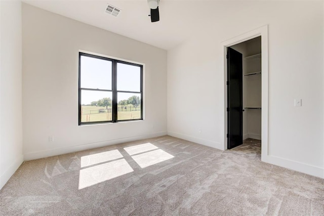 2223 Wintercreek Blvd, Blanchard, OK 73010 - unfurnished bedroom with light carpet, a walk in closet, a ceiling fan, and a closet