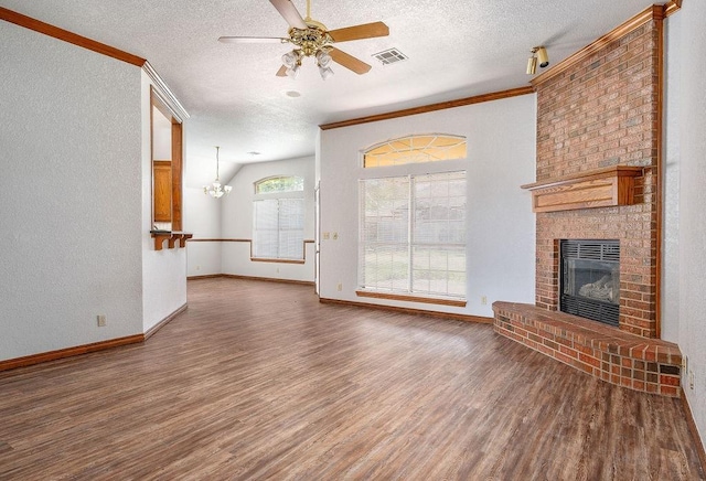 unfurnished living room featuring a textured ceiling, wood finished floors, crown molding, and a brick fireplace