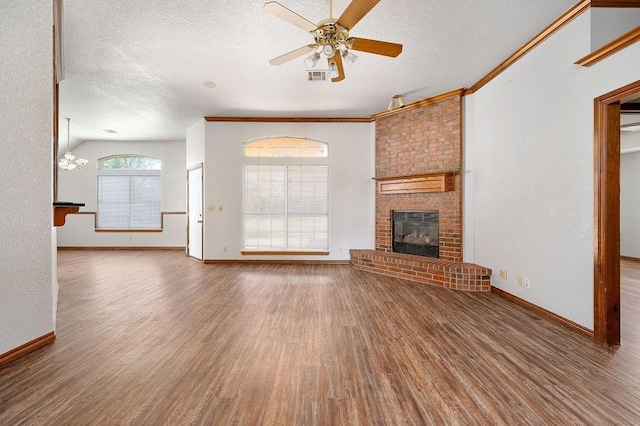 unfurnished living room with a fireplace, a textured ceiling, a ceiling fan, visible vents, and wood finished floors