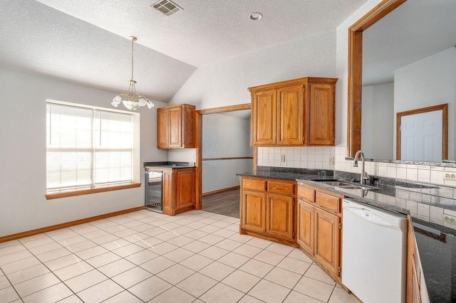 kitchen featuring a chandelier, brown cabinetry, decorative backsplash, white dishwasher, and a sink