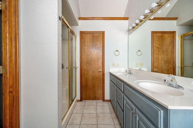 bathroom with a shower stall, a sink, and tile patterned flooring