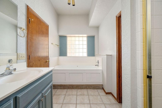full bath with tile patterned flooring, vanity, and a garden tub
