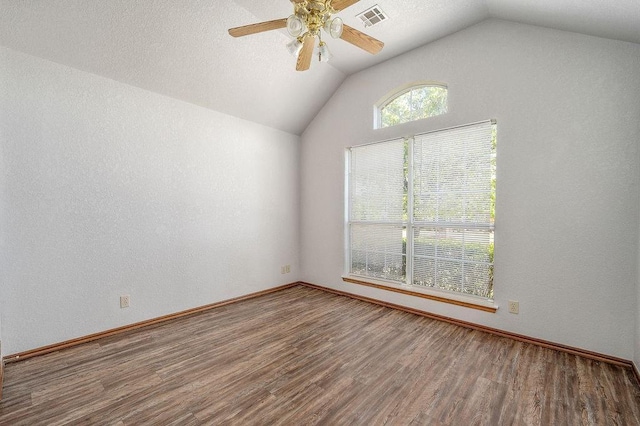 spare room featuring baseboards, a ceiling fan, visible vents, lofted ceiling, and wood finished floors
