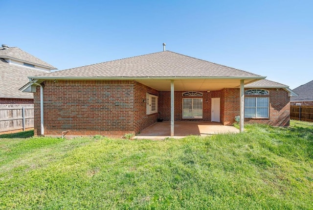 rear view of house with a patio, fence, and brick siding