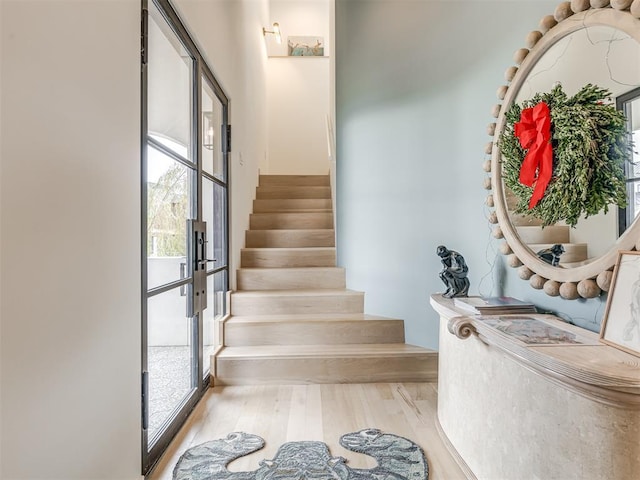 staircase featuring french doors and wood finished floors