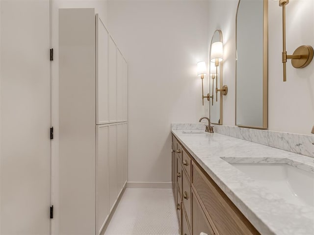 full bathroom featuring tile patterned flooring, baseboards, a sink, and double vanity