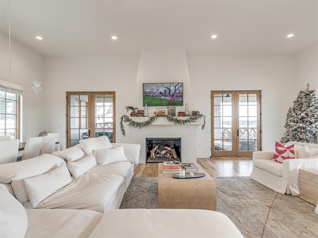 living room with recessed lighting, wood finished floors, a healthy amount of sunlight, and french doors