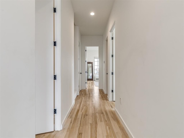 corridor with recessed lighting, light wood finished floors, and baseboards