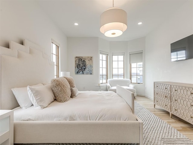 bedroom with baseboards, light wood finished floors, and recessed lighting