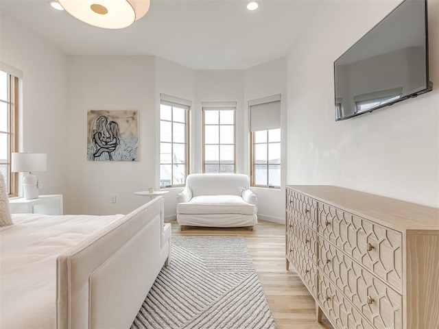 bedroom with baseboards, light wood finished floors, and recessed lighting