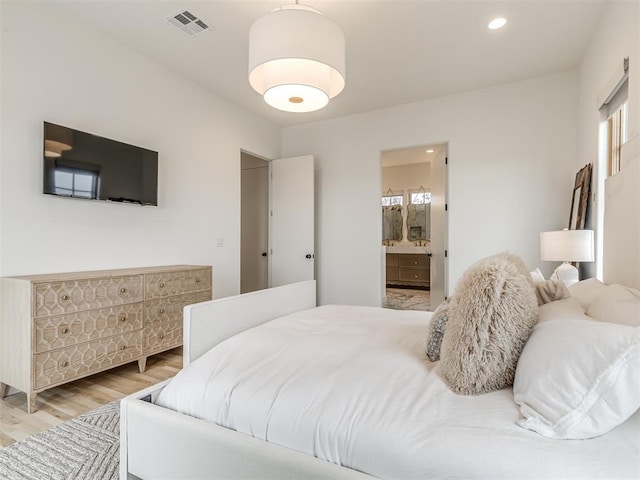 bedroom featuring recessed lighting, light wood-style flooring, visible vents, and connected bathroom