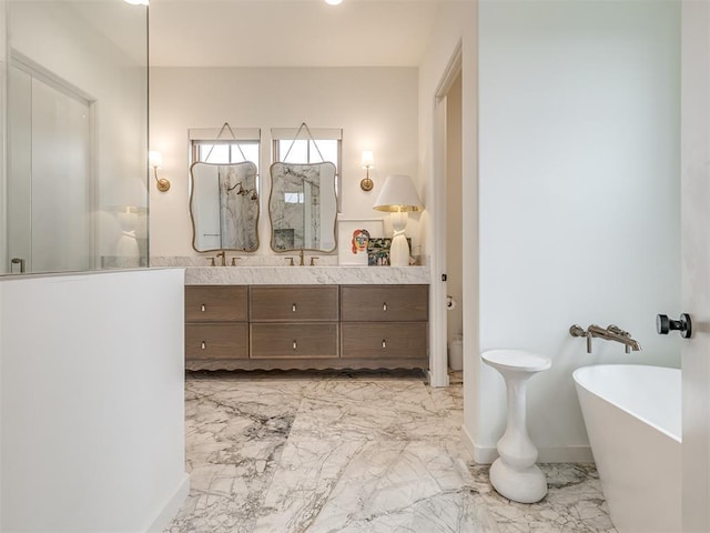 bathroom featuring a freestanding tub, vanity, marble finish floor, baseboards, and a walk in shower