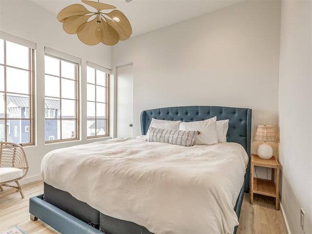 bedroom with light wood-type flooring and baseboards