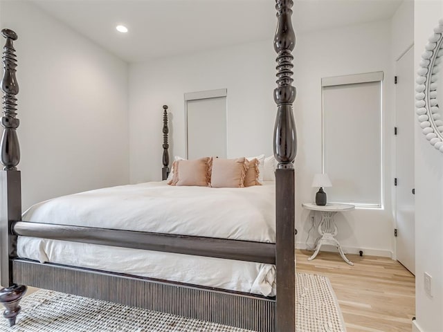 bedroom with recessed lighting, wood finished floors, and baseboards
