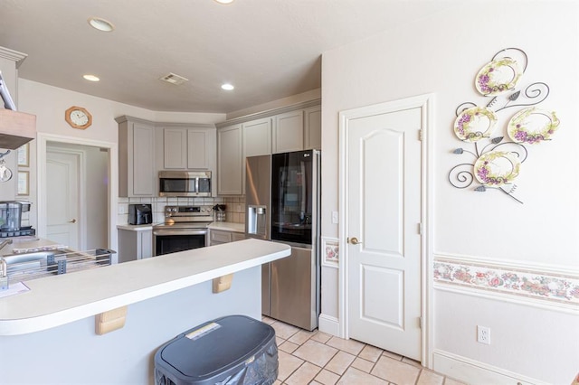 720 Northern Winds Dr, Purcell, OK 73080 - kitchen featuring stainless steel appliances, gray cabinetry, light countertops, a peninsula, and recessed lighting