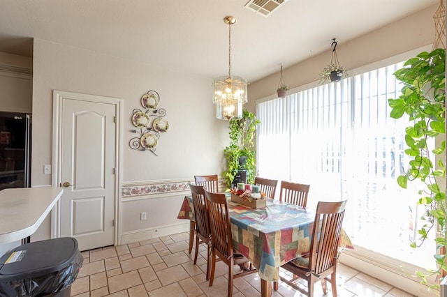 720 Northern Winds Dr, Purcell, OK 73080 - dining area with a chandelier, light stone finish flooring, and baseboards