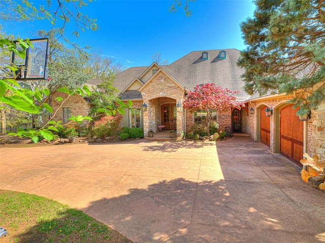 view of front of home with a shingled roof and stone siding