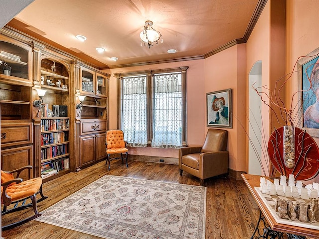 sitting room featuring dark wood finished floors, baseboards, and crown molding