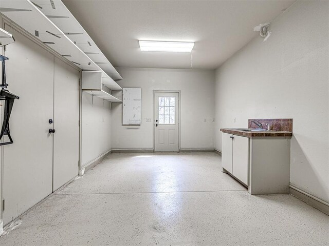garage with baseboards and a sink