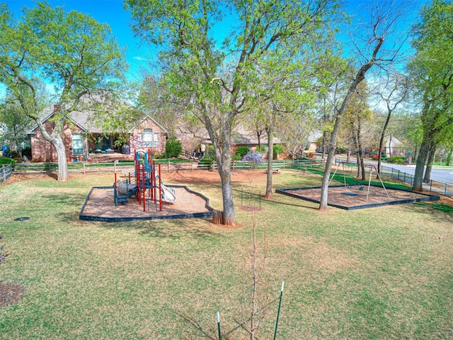 community jungle gym with fence and a yard