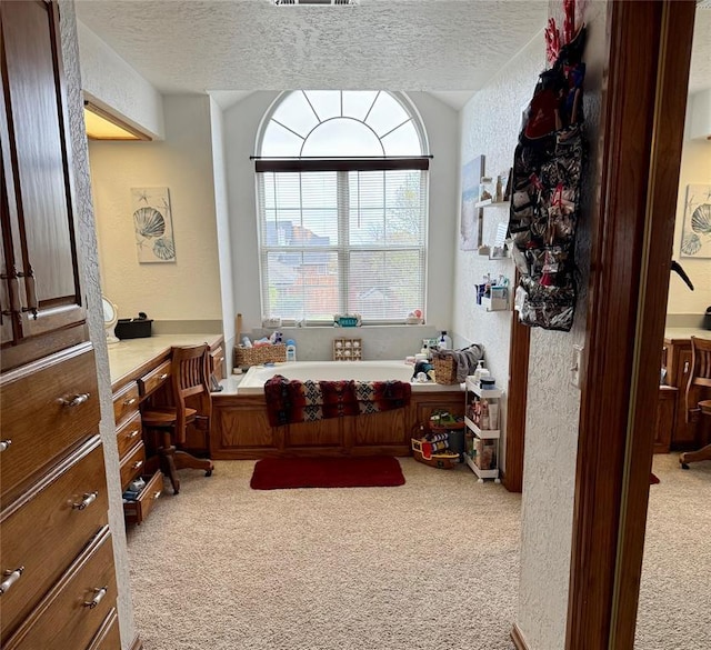 interior space featuring visible vents, a textured ceiling, a textured wall, and carpet