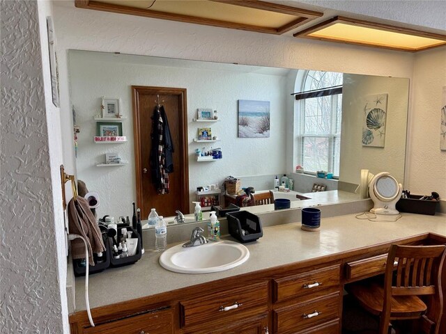 bathroom with vanity and a textured wall
