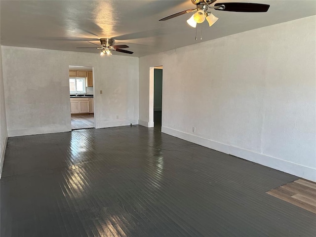 314 N Maryland Ave, Mangum, OK 73554 - spare room with baseboards, ceiling fan, and dark wood-type flooring