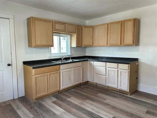 314 N Maryland Ave, Mangum, OK 73554 - kitchen with light brown cabinetry, dark countertops, a sink, and dark wood-type flooring