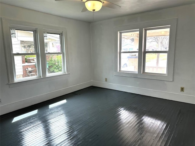 314 N Maryland Ave, Mangum, OK 73554 - spare room featuring baseboards, ceiling fan, and dark wood-type flooring