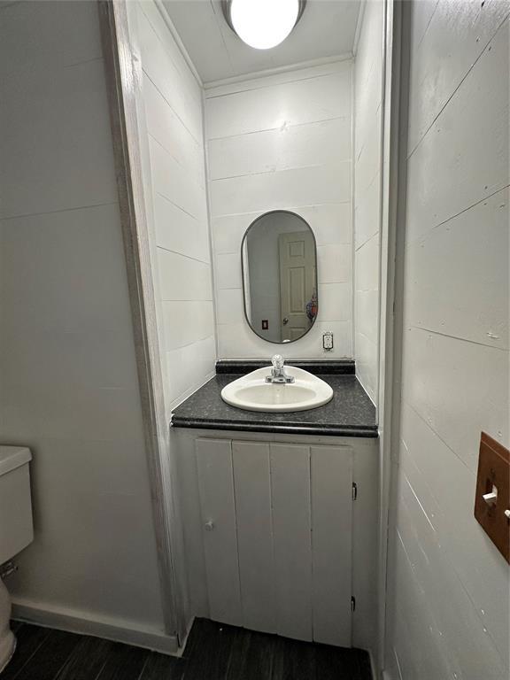 314 N Maryland Ave, Mangum, OK 73554 - half bathroom featuring wood finished floors and vanity
