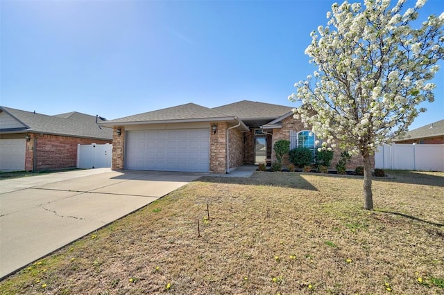 single story home featuring concrete driveway, a front lawn, brick siding, a garage, and fence
