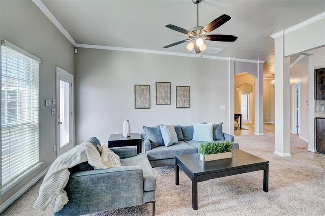 living area with baseboards, crown molding, a ceiling fan, arched walkways, and light colored carpet
