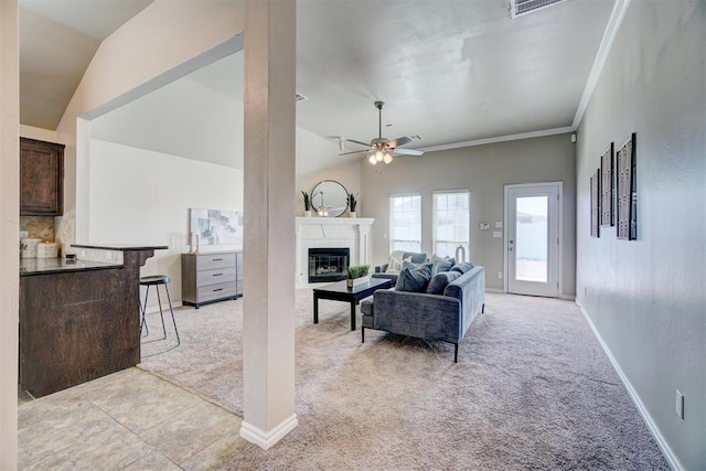 living room with light colored carpet, ceiling fan, a glass covered fireplace, and baseboards