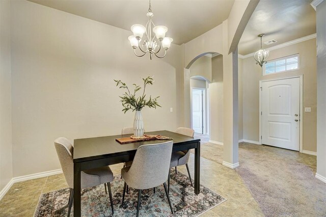 dining room with arched walkways, ornamental molding, visible vents, a chandelier, and baseboards