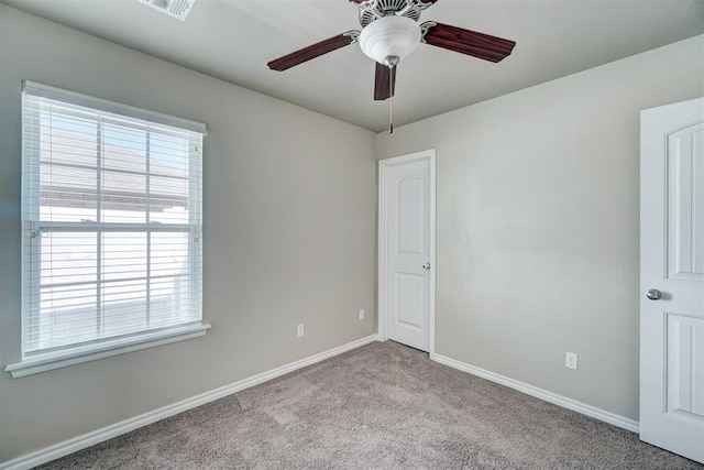 spare room featuring baseboards, a ceiling fan, and carpet