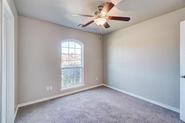 spare room with visible vents, ceiling fan, carpet flooring, and baseboards