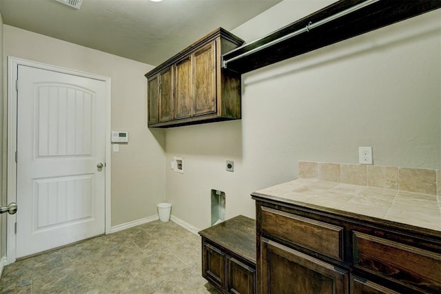 laundry room with electric dryer hookup, baseboards, hookup for a washing machine, and cabinet space