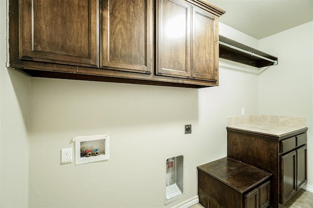 clothes washing area featuring electric dryer hookup, hookup for a washing machine, and cabinet space