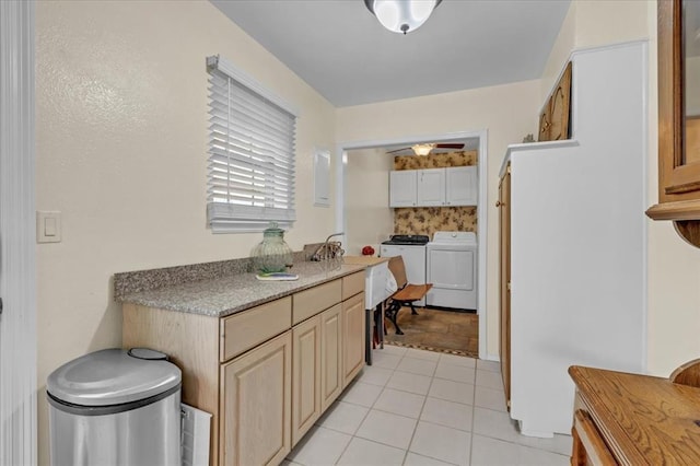 6706 N Woodward Dr, Oklahoma City, OK 73116 - kitchen with washing machine and dryer, light tile patterned flooring, and a sink