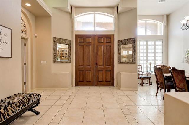 815 River View Dr, Norman, OK 73071 - entrance foyer with visible vents, a high ceiling, an inviting chandelier, and light tile patterned floors