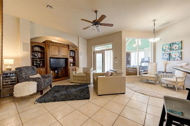 815 River View Dr, Norman, OK 73071 - living room featuring light tile patterned flooring, visible vents, arched walkways, and a ceiling fan