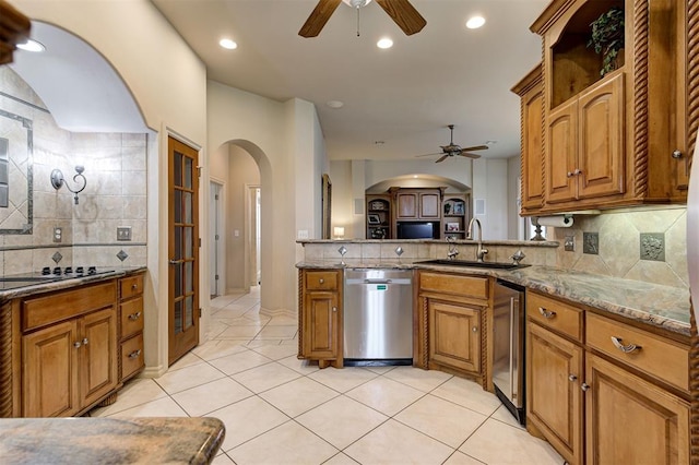 815 River View Dr, Norman, OK 73071 - kitchen with stainless steel dishwasher, black electric stovetop, arched walkways, and ceiling fan