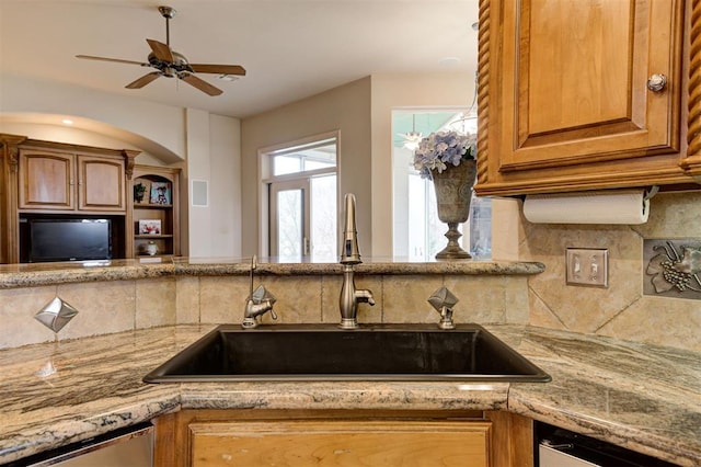 815 River View Dr, Norman, OK 73071 - kitchen with stainless steel dishwasher, light stone countertops, a sink, and backsplash