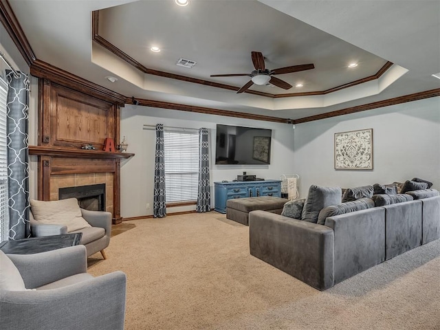 living room with visible vents, a tray ceiling, ceiling fan, and light carpet