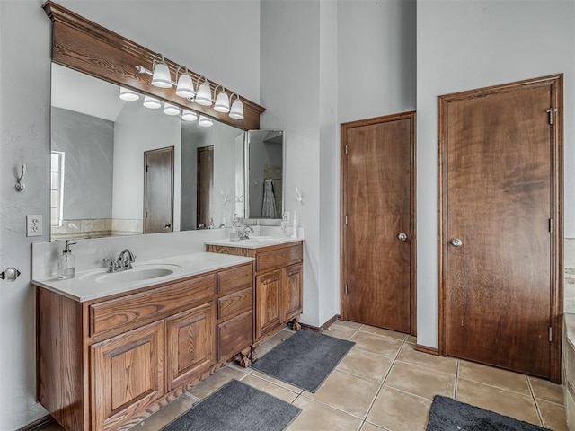 bathroom featuring tile patterned flooring, double vanity, and a sink